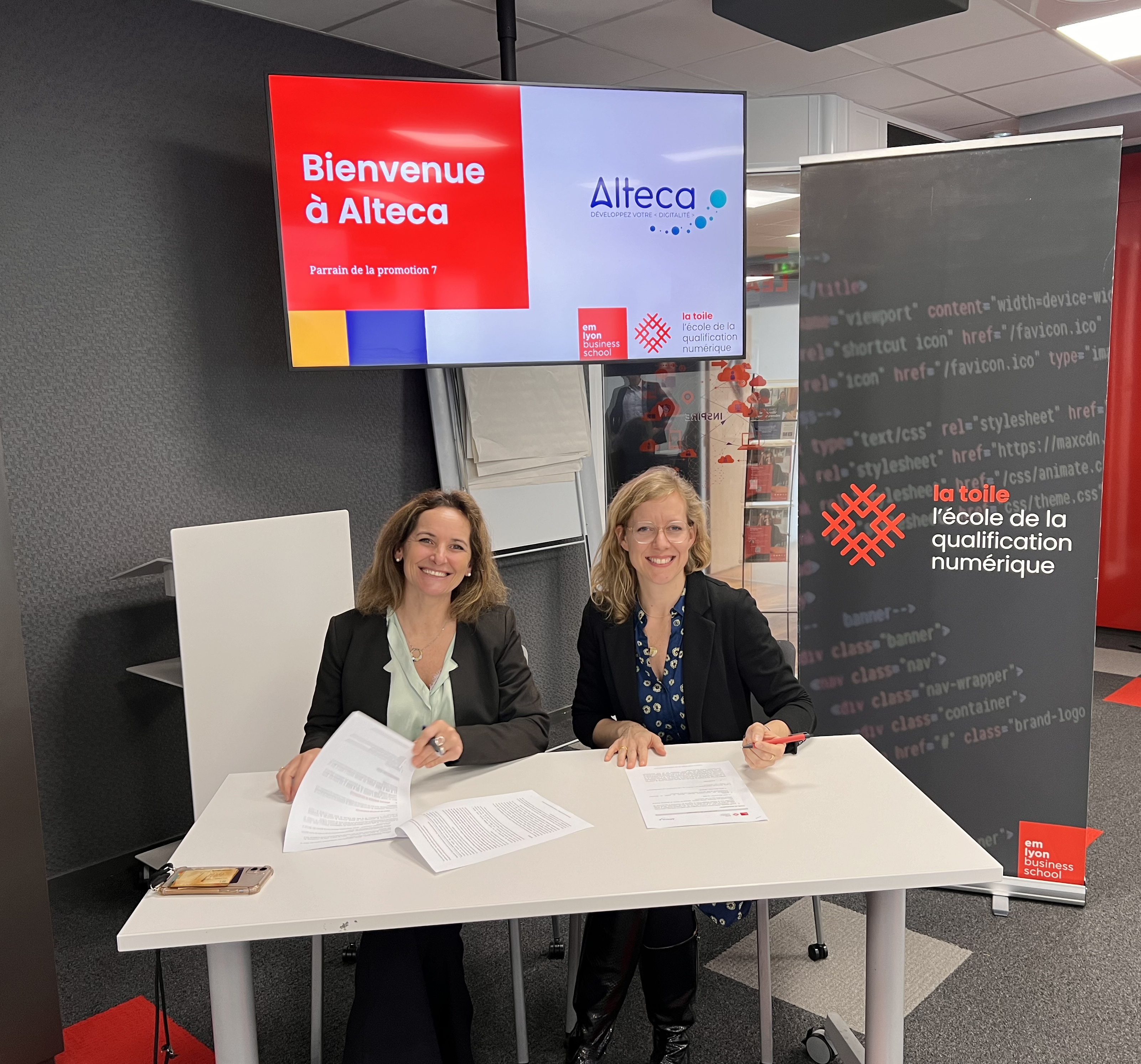 Deux femmes souriantes signent la charte